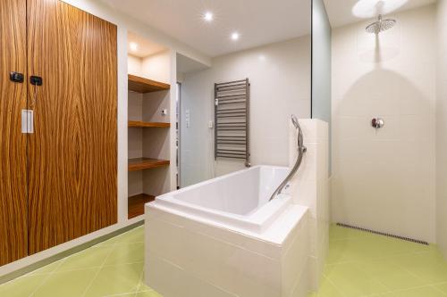 a white bath tub in a bathroom with green floors at AH Park Angelinum II in Košice