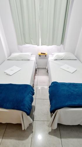 two beds sitting next to each other in a room at Dom Pablo Hotéis in São José dos Pinhais