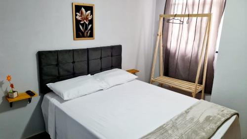 a bedroom with a white bed with a black headboard at Dom Pablo Hotéis in São José dos Pinhais
