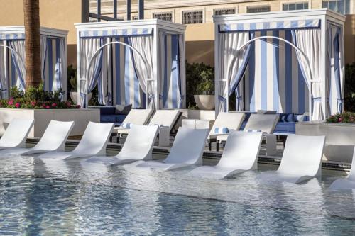 a row of white chairs next to a pool at The Venetian® Resort Las Vegas in Las Vegas