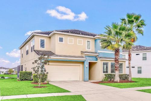 a house with a garage and a palm tree at 6BR Luxury Home w Pool Hot Tub and Games room in Kissimmee