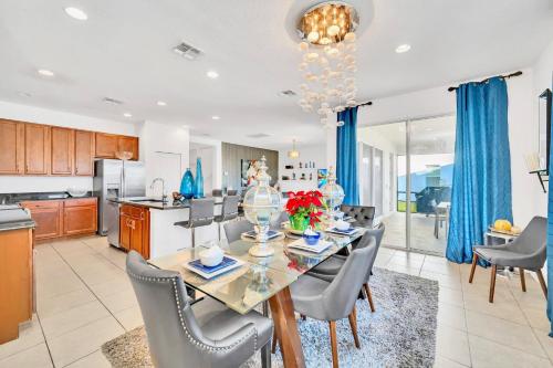 a dining room and kitchen with a table and chairs at 6BR Luxury Home w Pool Hot Tub and Games room in Kissimmee