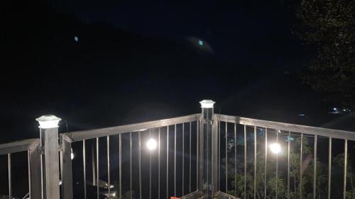 una cerca con luces encima de ella por la noche en Tangara Lodge, en San Gerardo de Dota