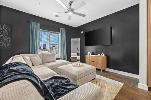 a living room with a couch and a flat screen tv at The Hollywood Suite The Gulch in Nashville