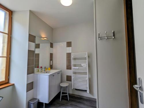 - une petite salle de bains blanche avec lavabo et tabouret dans l'établissement Gîte Levroux, 3 pièces, 5 personnes - FR-1-591-204, à Levroux