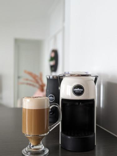 a coffee maker and a cup of coffee on a table at Spacious and Charming Queenslander in Ipswich in Bundamba