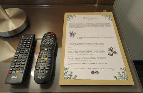 two remote controls sitting next to a menu on a table at Hotel Casino Morelia in Morelia