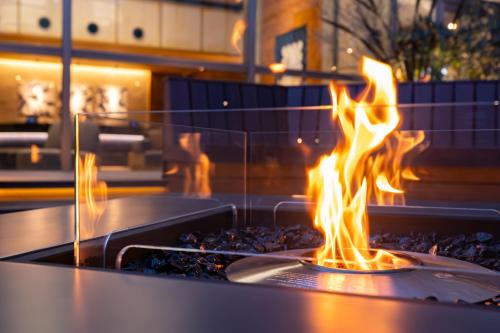 a fire in a grill with flames in it at -SPA RESORT- Nagoya Kasadera Hotel in Nagoya
