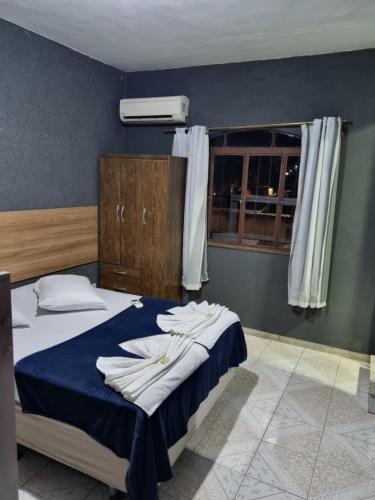 a bedroom with a bed with towels on it at Pousada Casa Familia in Nova Iguaçu
