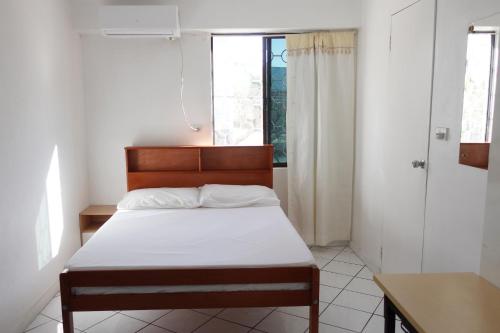 ein kleines Schlafzimmer mit einem Bett und einem Fenster in der Unterkunft Nadi Bethel Homestay in Nadi
