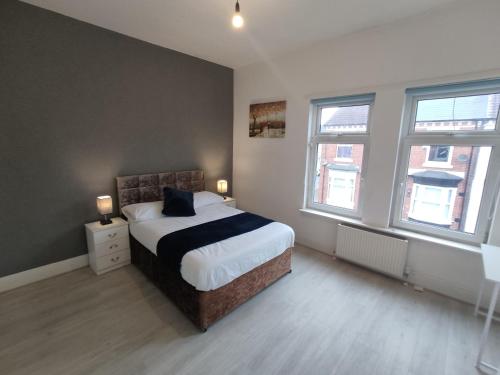 1 dormitorio con 1 cama y 2 ventanas en 3 Bedroom Entire House en Middlesbrough