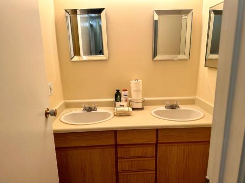 a bathroom with two sinks and two mirrors at Cozy private room in Edmonton in Edmonton