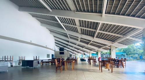 uma sala cheia de mesas e cadeiras de madeira em Enseada Nautico Residence DE PAULA em Caldas Novas