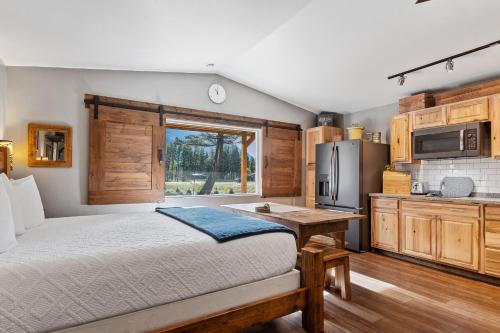 a bedroom with a bed and a kitchen with a refrigerator at Fort Williamson Glacier Vacation Rentals in Columbia Falls
