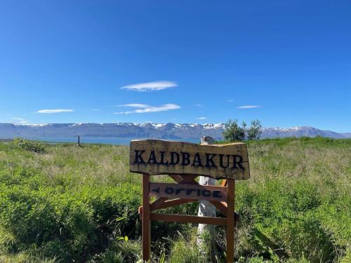 een teken dat zegt kadalbaru buitenpost in een veld bij Kaldbaks-kot cottages in Húsavík