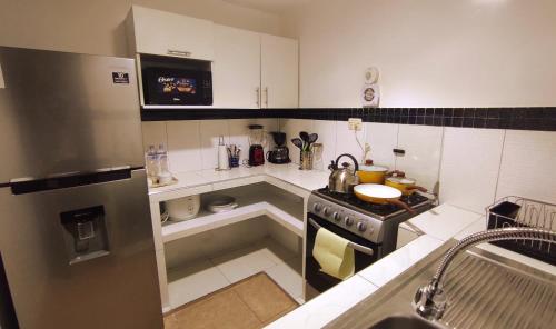 a small kitchen with a stove and a sink at ANDAHUAYLAS CENTRO in Andahuaylas
