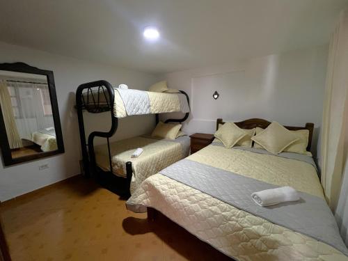 um pequeno quarto com 2 camas e um espelho em Anhyali Hospedaje em Villa de Leyva