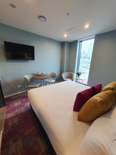 a hotel room with a large bed and a table at La Quinta by Wyndham Parnell Auckland in Auckland