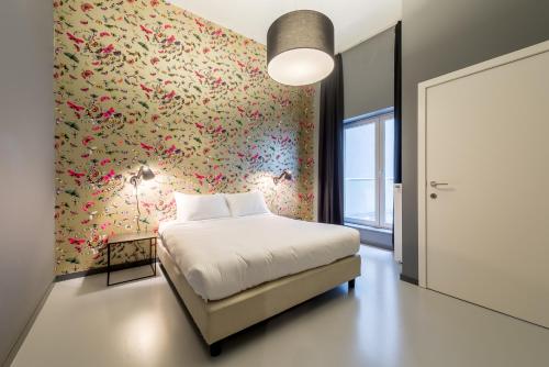 a bedroom with a bed and a flowery wall at Smartflats Design - Postiers in Brussels