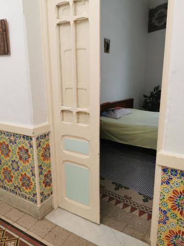a room with a door leading into a room with a bed at Dar Mima Baya in Tunis