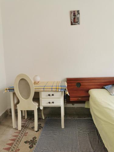 a bedroom with a desk with a chair and a bed at Dar Mima Baya in Tunis