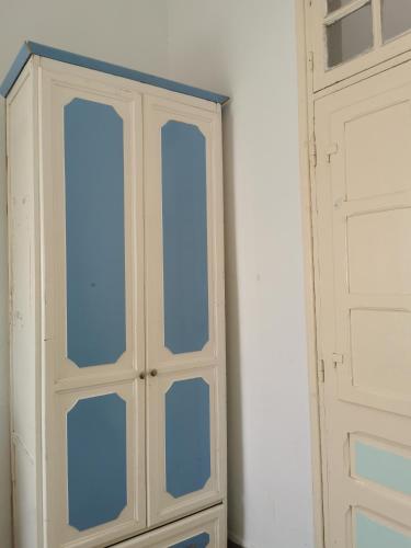 um armário branco com portas de vidro num quarto em Dar Mima Baya em Tunes