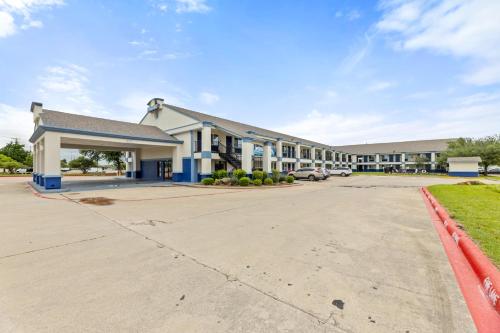 an empty parking lot in front of a building at Days Inn by Wyndham McKinney in McKinney