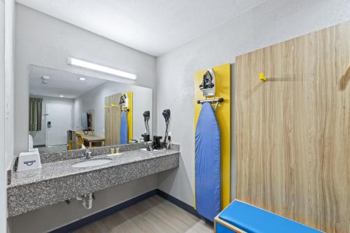 a bathroom with a sink and a mirror at Days Inn by Wyndham McKinney in McKinney