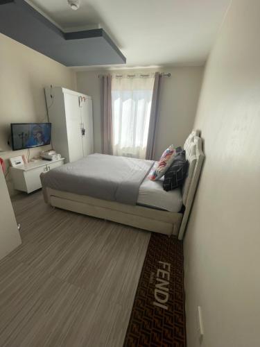 een kleine slaapkamer met een bed en een raam bij Spatial 8 condo in Davao City