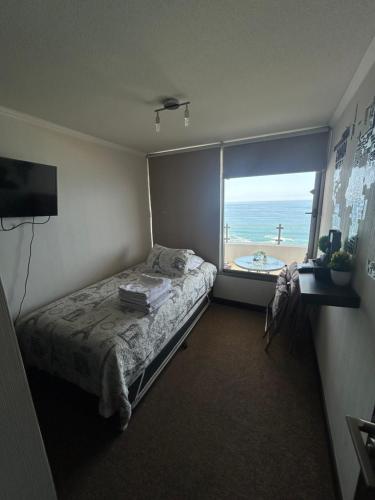 1 dormitorio con cama y vistas al océano en Departamento con hermosa terraza y vista panorámica al Mar 2D2B en Iquique