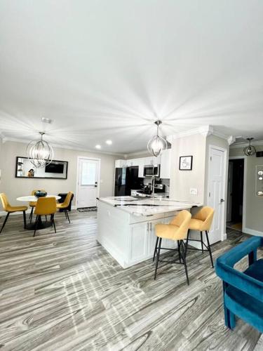 a living room with yellow chairs and a kitchen at Gemstones Sleeps 8 Perfect for Groups in Ladson