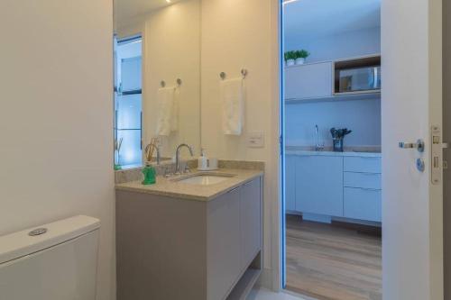 a bathroom with a sink and a mirror at Studio Campo Belo II in Sao Paulo