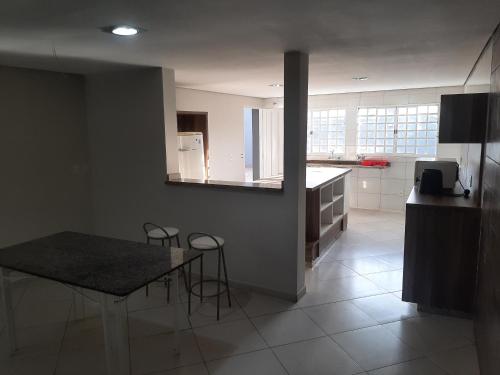 una cucina con un tavolo e sedie in una stanza di trabalho ou lazer a Marília