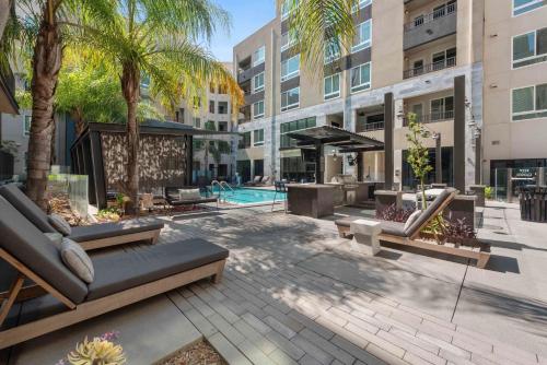 un patio esterno con piscina e palme di Cozy Glendale Apartment a Los Angeles