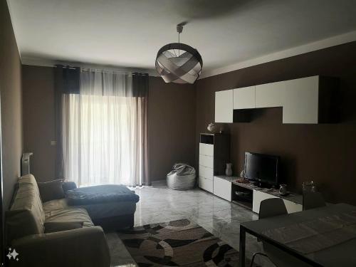 sala de estar con sofá y TV en Etna Holiday Apartment - Casa Vacanze en Fiumefreddo di Sicilia