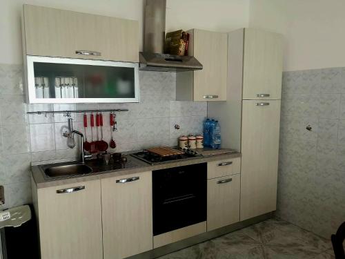 una cucina con lavello e fornello forno superiore di Etna Holiday Apartment - Casa Vacanze a Fiumefreddo di Sicilia