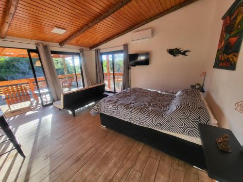 a bedroom with a bed and a balcony at LOBOS DEL BOSQUE CON JACUZZi in Punta Del Diablo