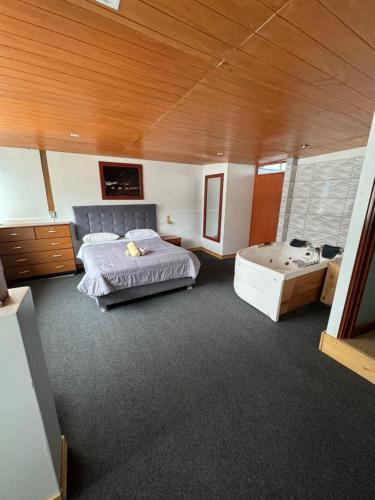 a bedroom with a bed and a tub in it at Hotel Alpamayo Guest House in Huaraz