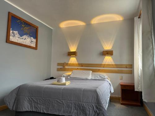 - une chambre avec un lit et deux lumières sur le mur dans l'établissement Hotel Alpamayo Guest House, à Huaraz