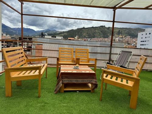 a patio with two chairs and a table on a roof at Hotel Alpamayo Guest House in Huaraz