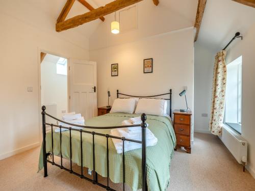 1 dormitorio con cama y ventana en Grooms Cottage, en Westbury on Severn
