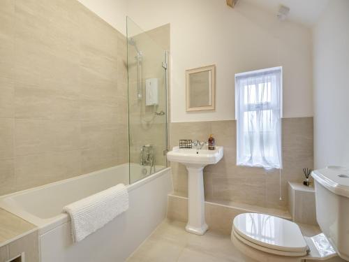y baño con lavabo, ducha y aseo. en Grooms Cottage, en Westbury on Severn