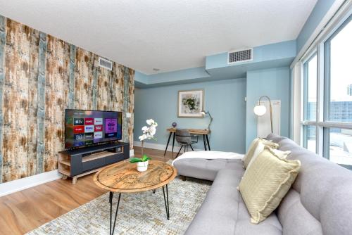 a living room with a couch and a tv at 300 Front Suites in Toronto