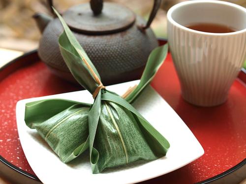 a plate of green leaves next to a cup of tea at Richmond Hotel Premier Kyoto Ekimae in Kyoto