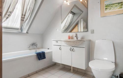 a bathroom with a toilet and a sink and a bath tub at 4 Bedroom Gorgeous Home In Skagen in Skagen