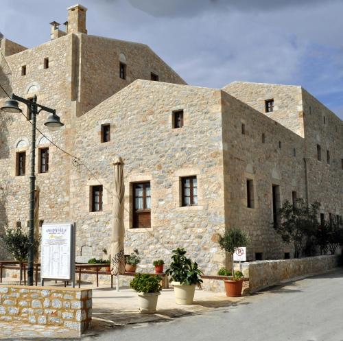 a large brick building with potted plants in front of it at Pyrgoi Theodorakaki: O Gerolimenas in Gerolimenas