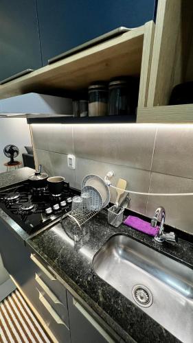 a kitchen counter with a sink and a stove at Studio 1304 Estilo e bem-estar no Cariri in Juazeiro do Norte