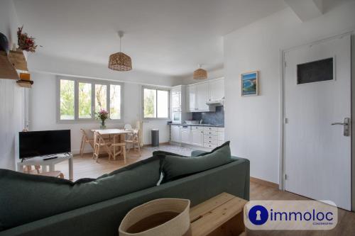 un salon avec un canapé vert et une cuisine dans l'établissement Apartment with air conditioning Libération, à Nice