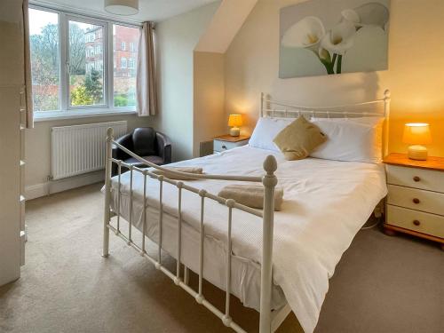 1 dormitorio con cama blanca y ventana en Holbeck House, en Scarborough