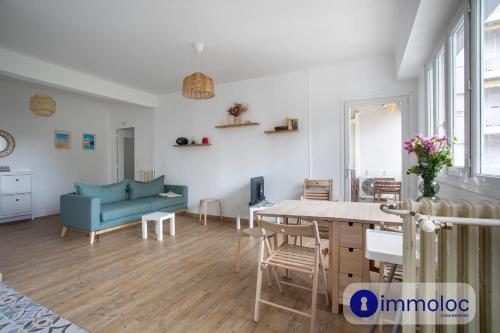 un salon avec un canapé bleu et une table dans l'établissement Apartment with air conditioning Libération, à Nice